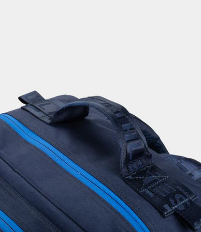 Black duffel bag with blue zipper on a light gray background