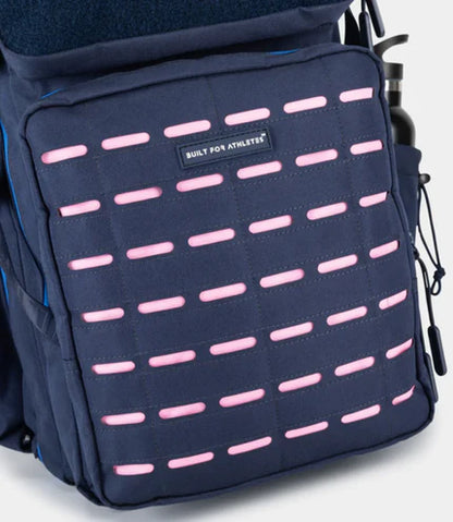Navy backpack with pink accents and a visible brand label on a light gray background