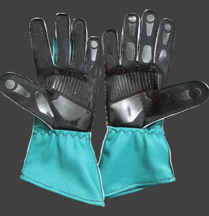Pair of gloves with black palm and teal cuffs on a dark background