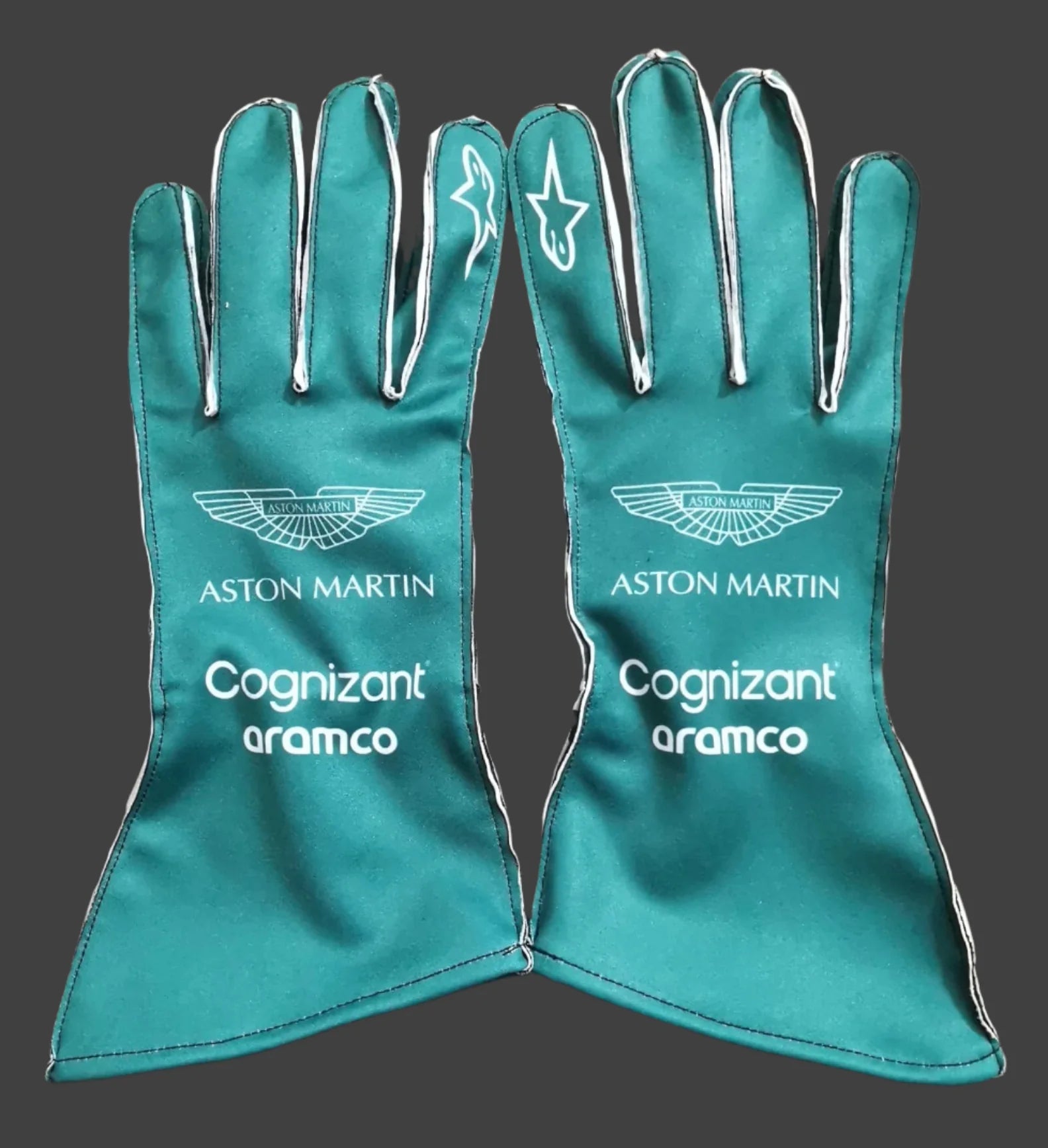 Teal racing gloves with Aston Martin and Cognizant Aramco logos on a dark background