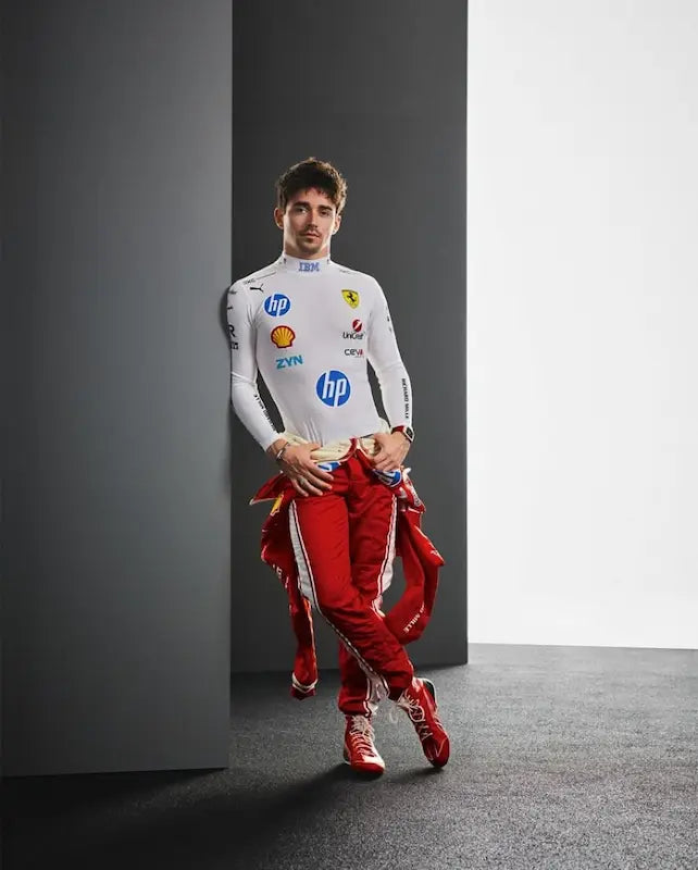 Person wearing a white racing suit with various sponsor logos on a gray background
