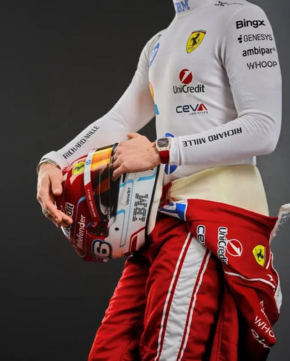 Person wearing a racing suit with various sponsor logos, holding a helmet.