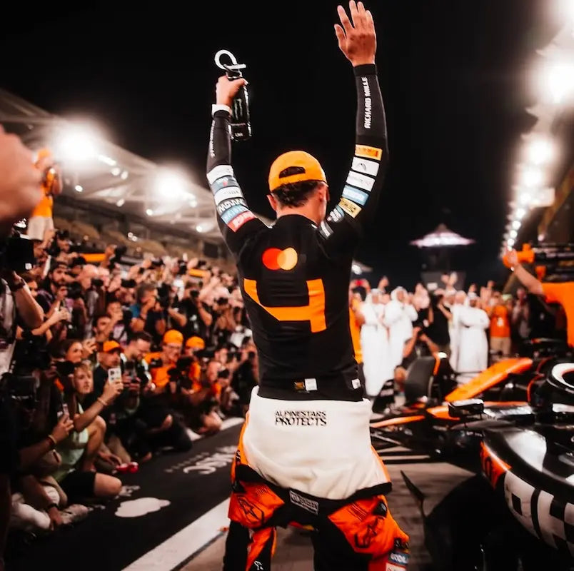Lando celebrating with a trophy on a race track in front of a crowd